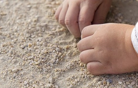 Kinderhände im Sand