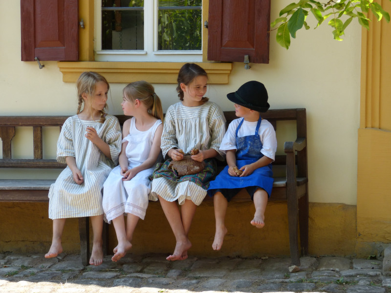 4 Kinder sitzen auf einer Bank
